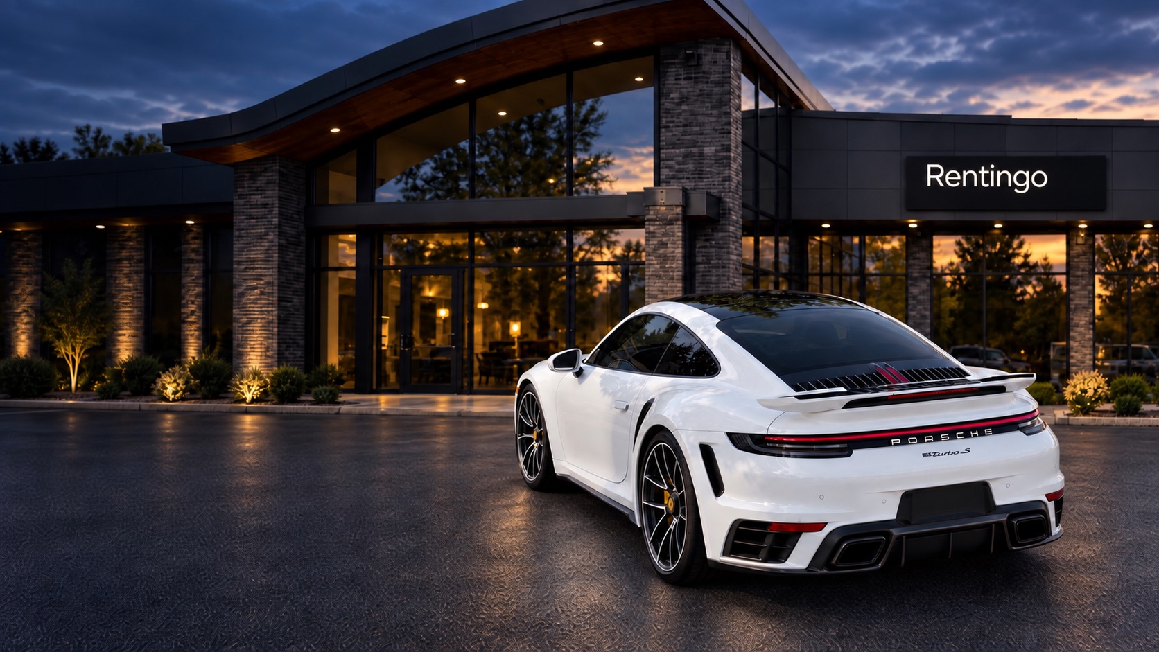 White Porsche 911 Turbo S against the Rentingo showroom at dusk
